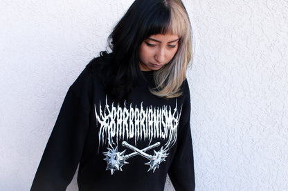Person wearing a black crewneck with white graphic design text stating "Barbarianism" and crossed mace brand logo against a white background